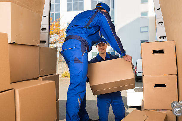 full length of young male movers carrying sofa outside truck on street